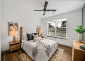 Thumbnail 18 of 20 - A bedroom with a bed, nightstand, and a ceiling fan at The Levi Luxury Apartments, McDonough, 30253