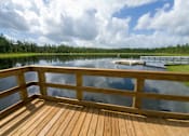 Thumbnail 124 of 124 - Wooden dock overlooking tranquil pond and tree line at Velara Luxury Apartments, Ponte Vedra Beach
