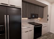 Thumbnail 6 of 13 - A black refrigerator is in a kitchen with white countertops at Verity Luxury Apartment Homes Apartments, Vero Beach, FL 32960