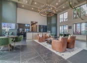 Thumbnail 11 of 30 - a lobby with chairs and tables and a large chandelier at Canter, Ocala, 34474
