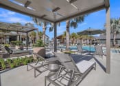 Thumbnail 9 of 30 - a patio with chairs and umbrellas next to a pool at Canter, Ocala, FL, 34474