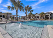 Thumbnail 4 of 30 - a swimming pool with palm trees and houses in the background at Canter, Ocala, Florida
