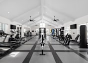 Thumbnail 32 of 36 - A spacious gym with treadmills, elliptical machines, and other exercise equipment.