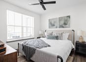 Thumbnail 20 of 36 - A bedroom with a large bed and a ceiling fan.