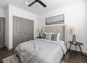 Thumbnail 19 of 36 - A bedroom with a large bed and a ceiling fan.