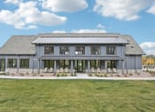 Thumbnail 22 of 53 - the front of a gray house with windows and a lawn at The Garrison Luxury Apartment Homes, Fountain, CO 80817