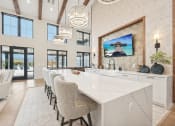 Thumbnail 27 of 53 - a large kitchen with a large marble counter top and chairs at The Garrison Luxury Apartment Homes, Fountain Colorado