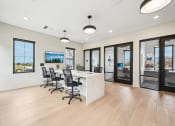 Thumbnail 35 of 53 - a conference room with a desk and chairs in front of a window at The Garrison Luxury Apartment Homes, Fountain, CO 80817