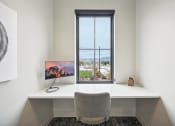 Thumbnail 36 of 53 - a desk with a computer and a window in a room at The Garrison Luxury Apartment Homes, Fountain Colorado