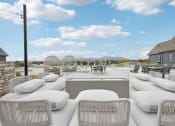 Thumbnail 39 of 53 - a patio with couches and chairs around a pool at The Garrison Luxury Apartment Homes, Fountain