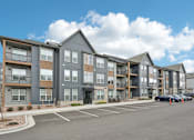 Thumbnail 49 of 53 - a large apartment building with a parking lot at The Garrison Luxury Apartment Homes, Colorado