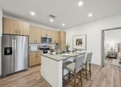 Thumbnail 8 of 53 - a kitchen with a large island and a stainless steel refrigerator at The Garrison Luxury Apartment Homes, Colorado
