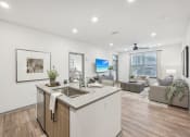 Thumbnail 9 of 53 - an open living area with a kitchen and a living room at The Garrison Luxury Apartment Homes, Fountain, 80817