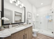 Thumbnail 14 of 53 - a bathroom with a shower and a sink and a mirror at The Garrison Luxury Apartment Homes, Fountain, 80817