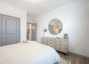 Thumbnail 17 of 53 - a white bedroom with a white bed and a mirror at The Garrison Luxury Apartment Homes, Fountain, 80817