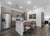 Thumbnail 66 of 115 - A kitchen with a refrigerator, microwave, and a counter with two chairs. at Terrassa Luxury Apartments, St. Augustine, FL, 32084
