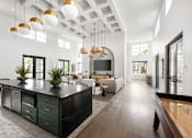 Thumbnail 68 of 68 - A modern kitchen with dark green cabinets and a long wooden island.