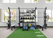 Thumbnail 63 of 68 - A gym with a green mat and weights.