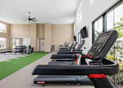 Thumbnail 61 of 68 - A gym with treadmills and a fan.