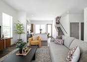 Thumbnail 59 of 68 - A living room with a grey couch and a coffee table.