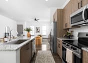 Thumbnail 60 of 68 - A modern kitchen with wooden cabinets and stainless steel appliances.