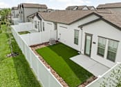 Thumbnail 6 of 68 - A white house with a green lawn in front.