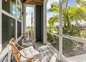 Thumbnail 66 of 83 - A balcony with a chair and a table. at Junction Apartments in Rockledge, FL