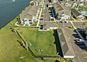 Thumbnail 77 of 83 - A bird's eye view of a residential area with houses, a road, and a body of water. at Junction Apartments in Rockledge, FL