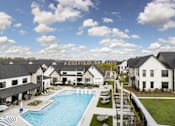 Thumbnail 10 of 59 - A large white building with a pool in front. at The Levi Luxury Apartments, McDonough, GA