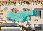 Thumbnail 97 of 108 - A large swimming pool surrounded by lounge chairs and umbrellas.