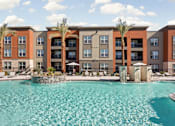 Thumbnail 96 of 108 - A large swimming pool in front of a multi-story apartment building.