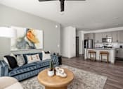 Thumbnail 2 of 108 - A living room with a blue couch and a painting on the wall.