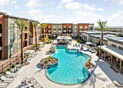 Thumbnail 1 of 108 - A large swimming pool surrounded by lounge chairs and palm trees.