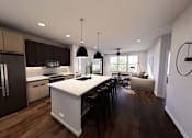 Thumbnail 18 of 34 - A modern kitchen with dark wood floors and white appliances. at Stack at Wheat Ridge Apartments, Colorado, 80033