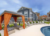 Thumbnail 3 of 40 - an outdoor pool with lounge chairs and a building in the background at Watermark on Twenty Mile, Colorado 80134