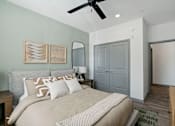 Thumbnail 48 of 108 - a bedroom with a large bed and a ceiling fan at The Maddox Luxury Apartment Homes, Buckeye, 85326  