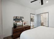 Thumbnail 54 of 108 - a bedroom with a large white bed and a wooden dresser at The Maddox Luxury Apartment Homes, Buckeye Arizona  