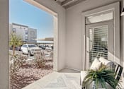 Thumbnail 45 of 108 - a patio with a chair and a door to a parking lot at The Maddox Luxury Apartment Homes, Arizona, 85326 