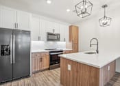 Thumbnail 63 of 108 - a kitchen with a large island and stainless steel refrigerator at The Maddox Luxury Apartment Homes, Arizona, 85326 