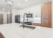Thumbnail 67 of 108 - a large kitchen with white counter tops and a sink at The Maddox Luxury Apartment Homes, Buckeye Arizona  