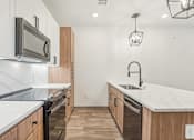 Thumbnail 62 of 108 - a renovated kitchen with marble counter tops and wooden cabinets at The Maddox Luxury Apartment Homes, Arizona  
