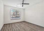 Thumbnail 57 of 108 - an empty living room with a ceiling fan and a window at The Maddox Luxury Apartment Homes, Buckeye, AZ 85326  