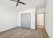 Thumbnail 70 of 108 - an empty living room with a ceiling fan and a door to a closet at The Maddox Luxury Apartment Homes, Arizona, 85326 