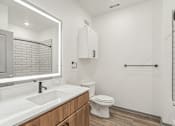 Thumbnail 69 of 108 - a bathroom with a sink and a toilet and a mirror at The Maddox Luxury Apartment Homes, Arizona  