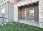 Thumbnail 59 of 108 - a rendering of the front porch of a house with green grass at The Maddox Luxury Apartment Homes, Buckeye, 85326  