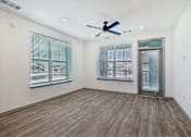 Thumbnail 86 of 108 - an empty living room with a ceiling fan and two windows at The Maddox Luxury Apartment Homes, Arizona  