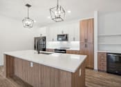 Thumbnail 66 of 108 - a white kitchen with wooden cabinets and a white counter top at The Maddox Luxury Apartment Homes, Buckeye, 85326  