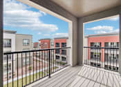 Thumbnail 77 of 108 - a balcony with a view of a yard and apartment buildings at The Maddox Luxury Apartment Homes, Buckeye, 85326  