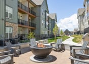 Thumbnail 2 of 38 - an outdoor area with a fire pit in front of an apartment building at Upland Flats, Colorado Springs, CO, 80922