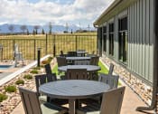 Thumbnail 32 of 38 - a patio with a table and chairs outside of a house at Upland Flats, Colorado Springs, CO, 80922